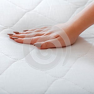 Choice comfortable mattress for sleep in store. Quality control hardness of white mattress. Woman choosing new mattress. Female