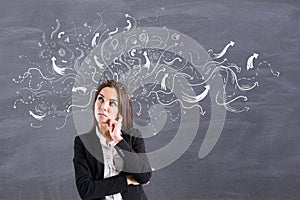 Choice concept with doubtful businesswoman on blackboard background with chalk arrows directed