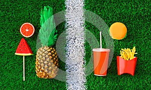 Choice of healthy or unhealthy food concept - burger, french fries, cup of juice and pineapple, lollipop or ice cream shaped slice