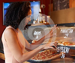 Choice, hungry and woman buying pizza for lunch with a decision, looking and choosing at a shop. Food, happy and girl