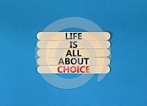 Choice and life symbol. Concept words Life is all about choice on wooden stick. Beautiful blue table blue background. Business