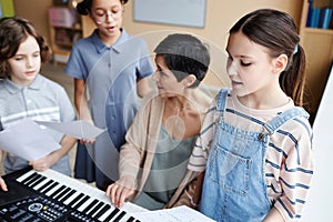 Choir of children singing songs with teacher