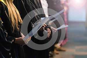 Choir singers holding musical score and singing on student gradu