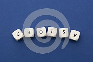 Choise word, lettering written on wooden blocks over blue background