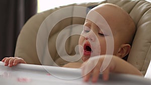 choke on baby child sitting feeding chair indoors, trying spit out food, opened