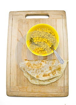 Chole with Aloo Paratha or Alu parantha a type of bread with bowls of peas curry over on white background