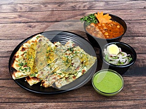 Chole Kulcha, Clay baked stuffed Naan served with channa masala or chole masala, typical meal of Amritsar, India. isolated over a