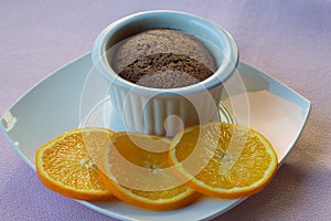 Chololate soufflÃ© with slices of orange as decoration