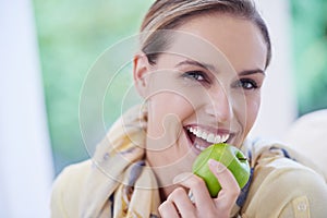 Choose a healthy snack. Portrait of a beautiful woman holding a apple.