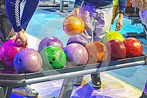 choose multi-colored balls according to their heaviness for the game of bowling. photo