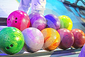 choose multi-colored balls according to their heaviness for the game of bowling. photo