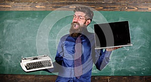 Choose right teaching method. Modern instead outdated. Teacher bearded hipster holds typewriter and laptop. Teacher