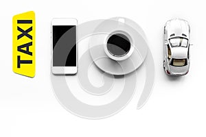 Choose a taxi in mobile application. Taxi label, cell phone, car toy on white background top view copyspace