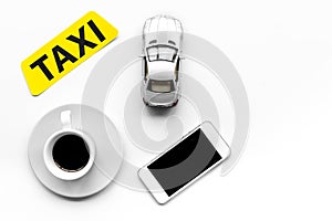 Choose a taxi in mobile application. Taxi label, cell phone, car toy on white background top view copyspace