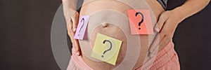 Choosing baby name. Confused pregnant woman with question marks on paper stickers on tummy BANNER, LONG FORMAT