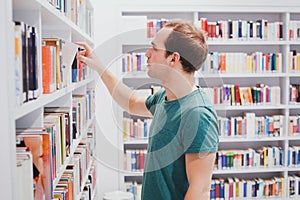Choosing book in library or bookshop, student picking literature