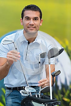 choosing golf club on retail shop background
