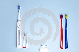 Choosing between manual and electric toothbrushes on blue background