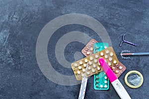 Choosing method of contraception : Birth control pills, an injection syringe, condom, IUD-method, on grey