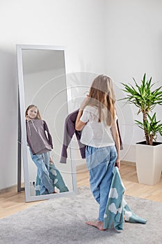 Choosing Outfits: Child with Clothes by Mirror. Morning preparation before school