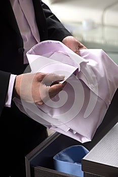 Choosing the right shirt. Close-up of businessman holding a shirt in his hands