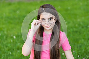 Choosing trendy accessories. Little girl wear glasses green grass. Fashion accessories. Designer eyewear and accessories