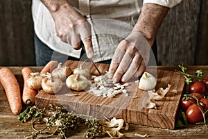 Chop onion on wooden chopping board - healthy and traditional eating - desaturated effect - selective focus