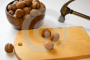 Chop  walnuts with a hammer on a cutting board. strong natural walnuts in  kitchen