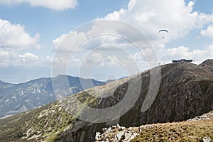 Chopok 2024m summit with a top Cable cars terminal station and flying paraglider. Low Tatras Nizke Tatry Crest Trail landscape