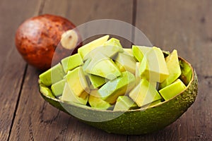 Chopped avocado fruit on brown wooden old table