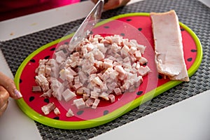 Chopped bacon on a plate, ready to fry in a pan