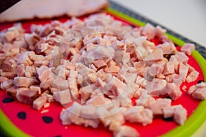 Chopped bacon on a plate, ready to fry in a pan