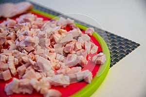 Chopped bacon on a plate, ready to fry in a pan