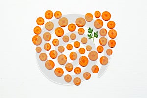 Chopped carrot slices heart shape and parsley leaves.