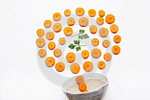 Chopped carrot slices and parsley leaves with bowl.