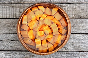 Chopped carrots in bowl on wooden table. Healthy diet, vitamin salad for vegetarian