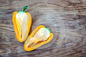 Chopped cut colorful vibrant bright yellow fresh ripe sweet pepper on old cutting wooden board table background