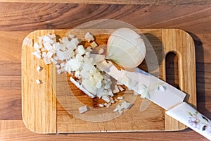 Chopped fresh onion on a cutting board with knife