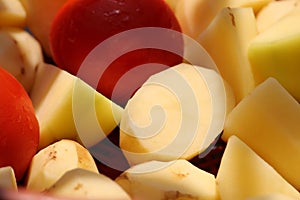 Chopped fresh potato pieces with red tomato together display ready to cook.