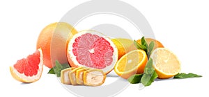 Chopped fruits over the white background. Colorful grapefruit, lemon, oranges. Fresh mint leaves and slices of a banana.