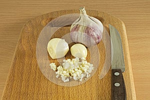 Chopped garlic on a wooden cutting board photo
