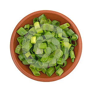 Chopped green onions in a small red clay bowl