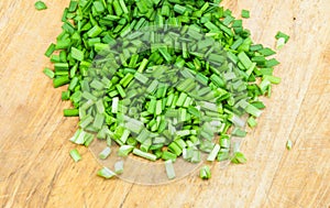 Chopped green onions on a wooden chopping board