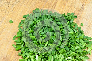 Chopped green onions on a wooden chopping board