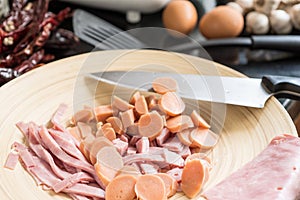 Chopped ham and Sausage on chopping block with knife