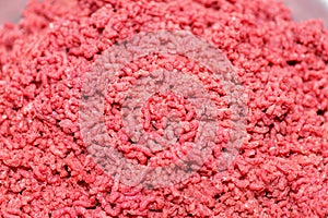 Chopped meat through manual meat grinder close-up. Copy space on the background of ground beef. Cooking minced meat from fresh mea