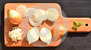 Chopped onion and slices of onion on chopping board