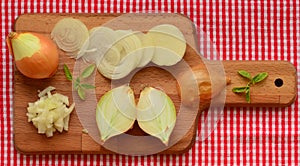 Chopped onion and slices of onion on chopping board