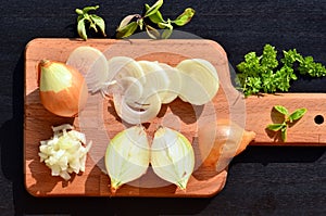 Chopped onion and slices of onion on chopping board