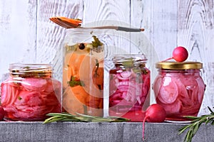 Chopped radish, carrot and red onion marinated in glass jars